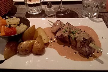 A plate of food with meat and potatoes on a table