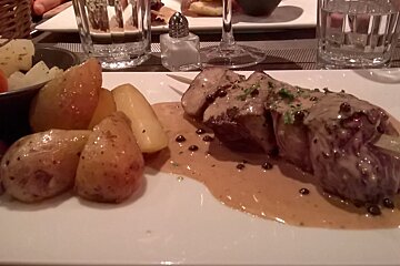 A plate of food with potatoes and meat on a table