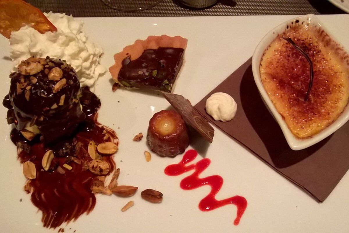A plate of desserts with a swirl of red sauce on it