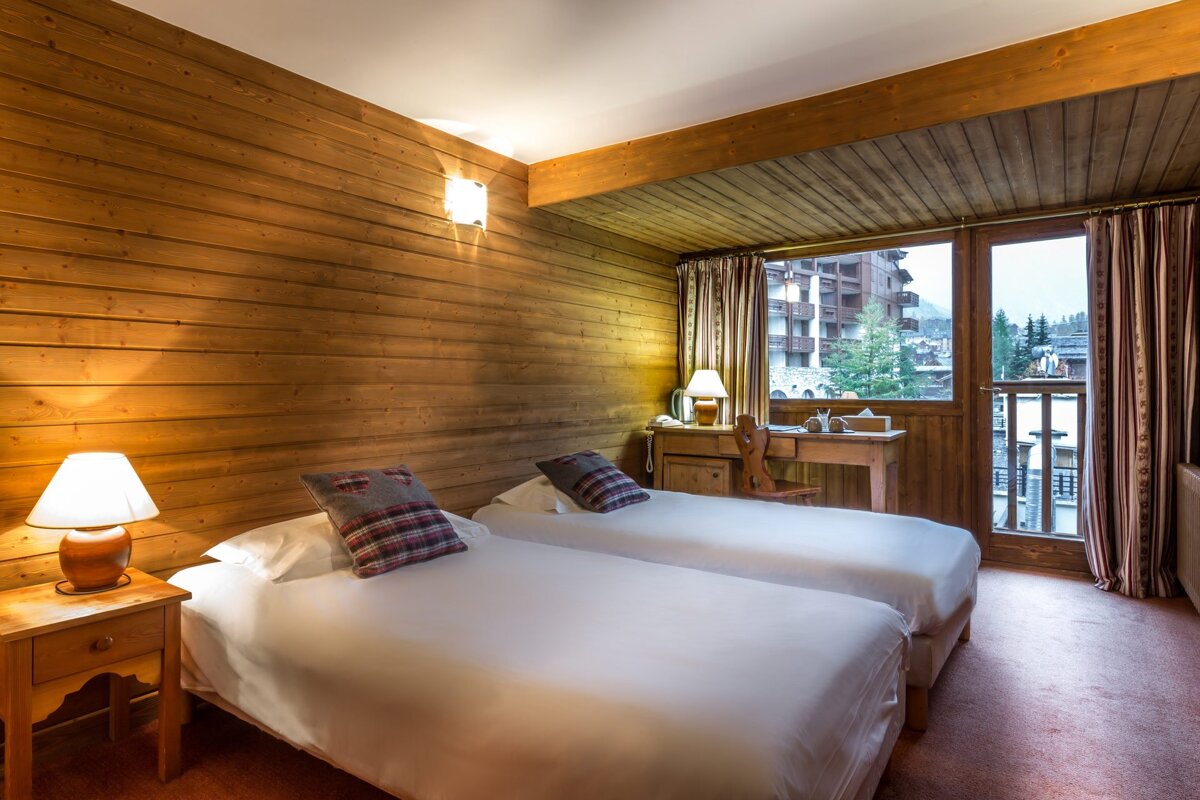 A hotel room with two beds and a desk