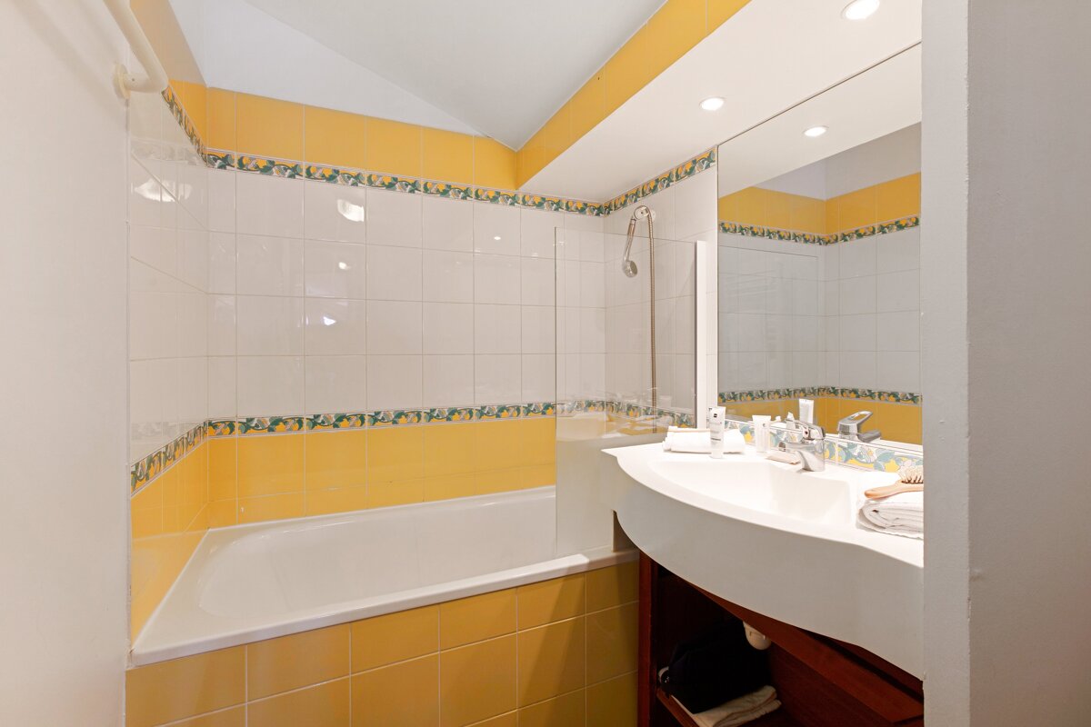 A bathroom with yellow tiles and a sink