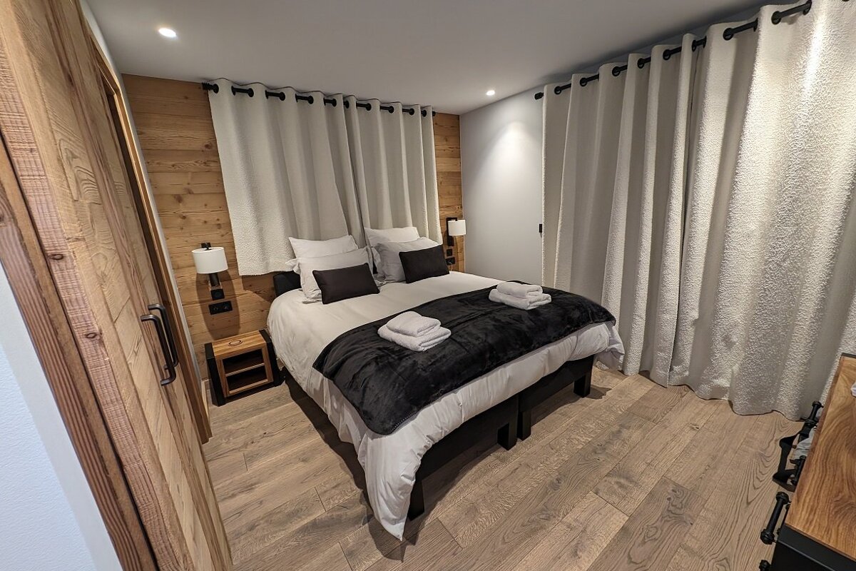 A bedroom with a large bed and white curtains