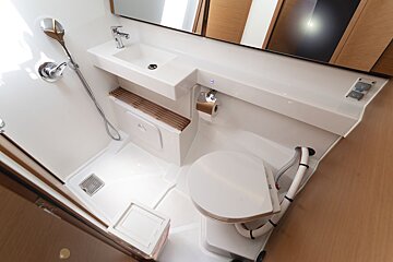 A bathroom with a toilet a sink and a mirror