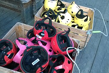 multicoloured helmets in wooden boxes