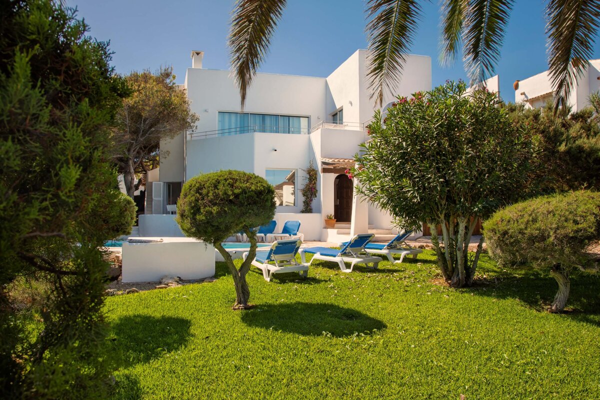 A white house with blue chairs in front of it