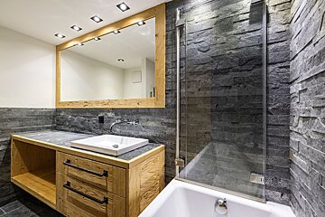 A bathroom with a sink a mirror and a bathtub