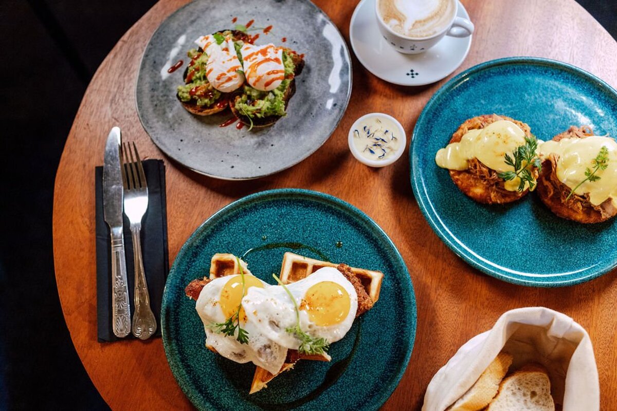 A table topped with plates of food and a cup of coffee