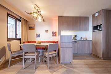 A kitchen with a table and chairs and a coffee maker