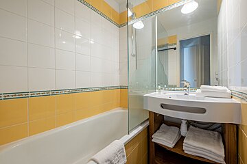 A bathroom with yellow and white tiles and a sink
