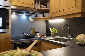 A kitchen with a stove top oven and a sink