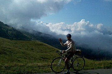 a man on a road bike looking at the view of the mountains