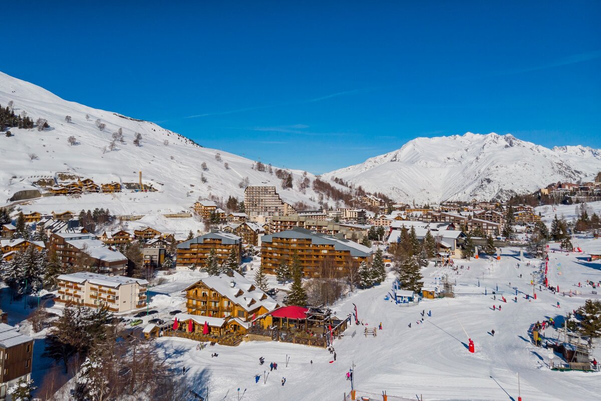 An aerial view of a ski resort with mountains in the background