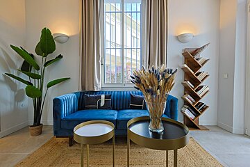 A living room with a blue couch and a bookshelf