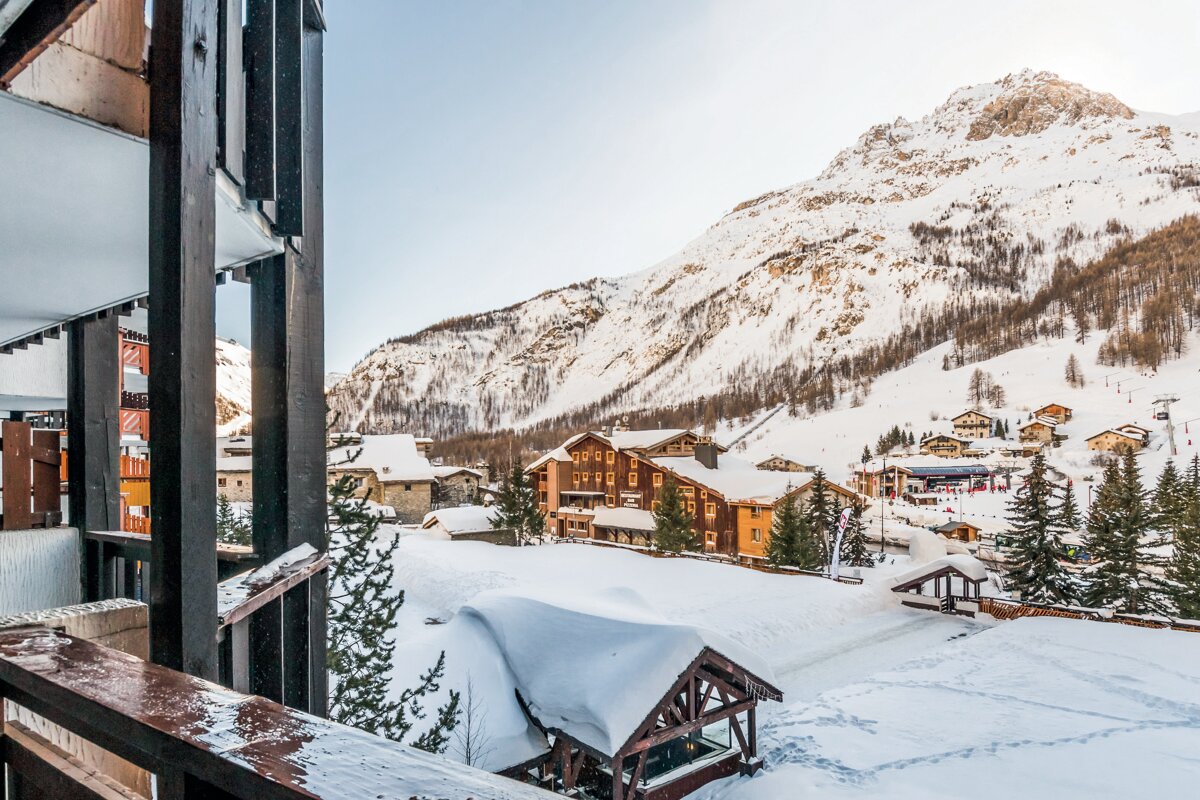 A view of a snowy mountain village from a balcony