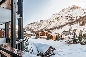 A view of a snowy mountain village from a balcony