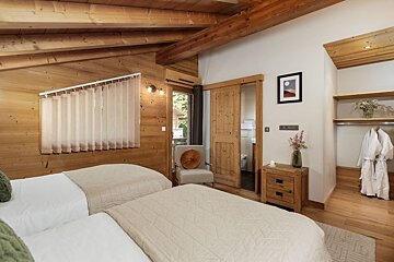 A bedroom with two beds and a picture on the wall