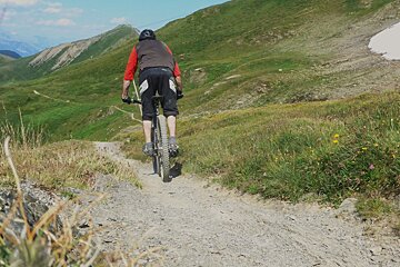 a mountain biker heading off onto a trail in chamonix