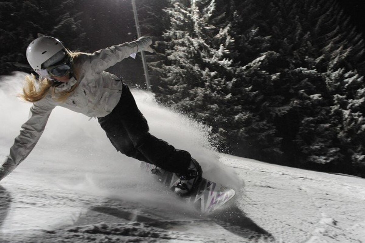 a female snowboarder with a white helmet