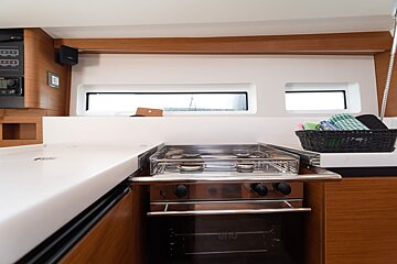 A kitchen with a stove and a basket of towels