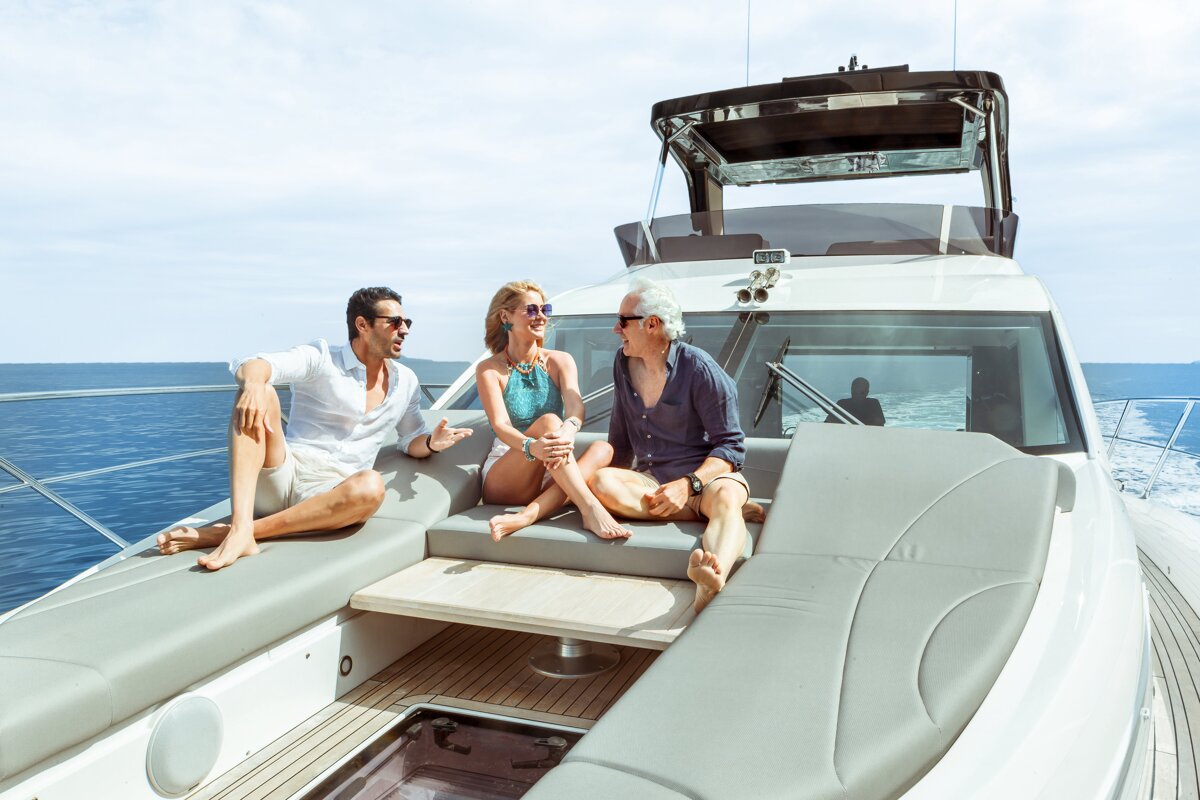 Two men and a woman are sitting on the back of a boat