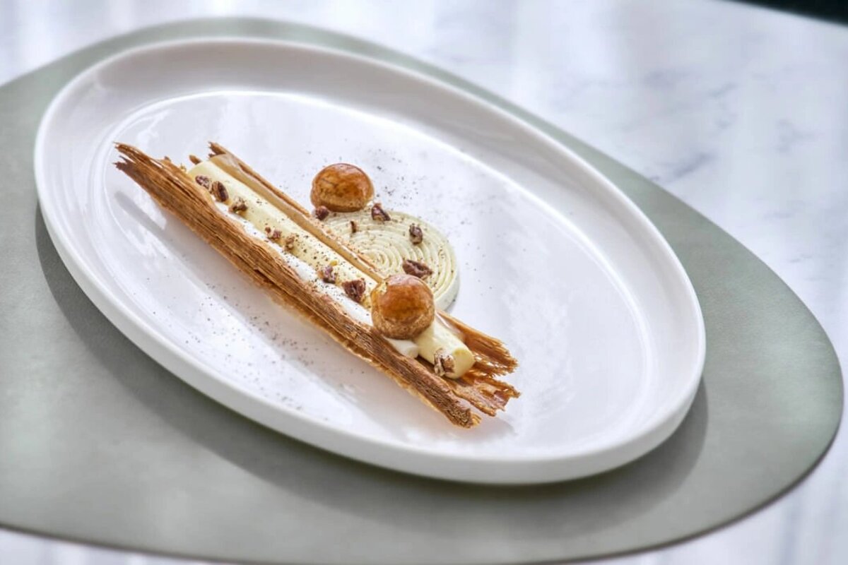A white plate with a dessert on it on a table