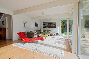 A living room with a couch and a red chair