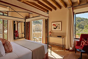A bedroom with a canopy bed and a red chair