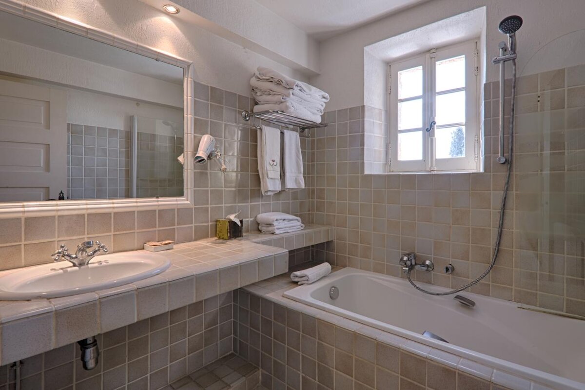 A bathroom with a sink and bathtub and a window