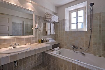 A bathroom with a sink and bathtub and a window