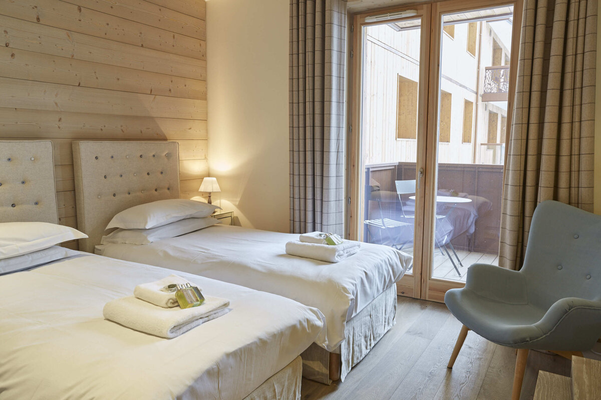 A hotel room with two beds and a chair