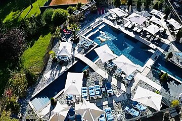 An aerial view of a large swimming pool surrounded by chairs and umbrellas