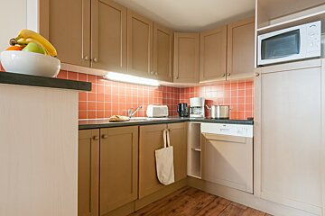 A kitchen with a microwave and a toaster oven