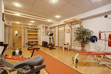 A gym with an exercise bike and a bench