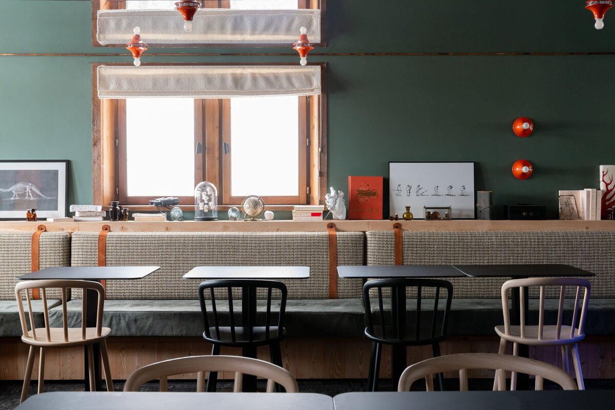 Tables and chairs in a room with a green wall
