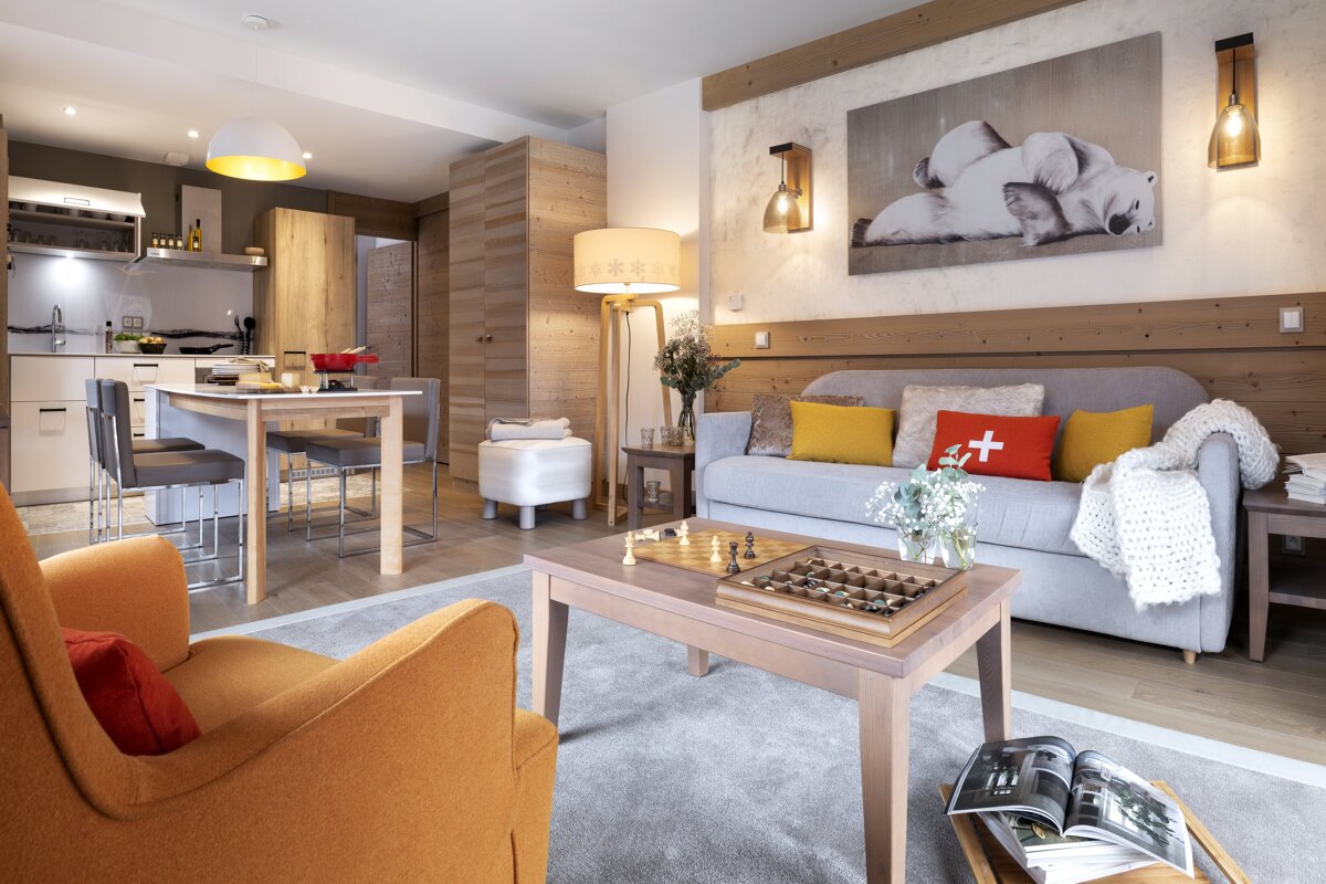 A living room with a couch and a table with a chess board on it