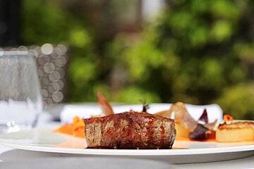 A white plate with a piece of meat on it