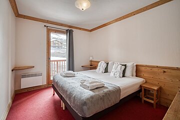A bedroom with a large bed and a window