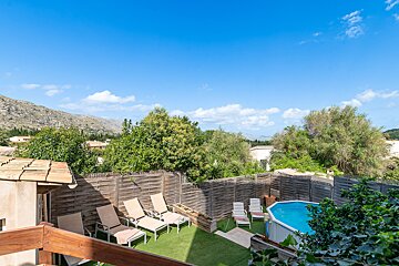 A fenced in area with chairs and a swimming pool