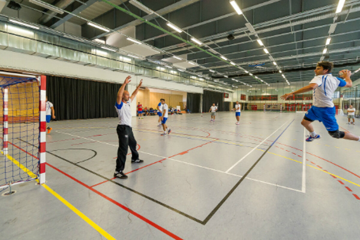A group of people are playing a game of handball