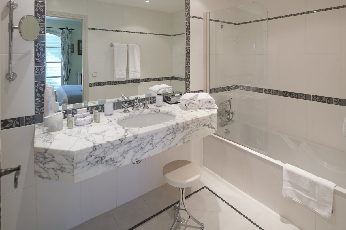 A bathroom with a marble counter top and a bathtub