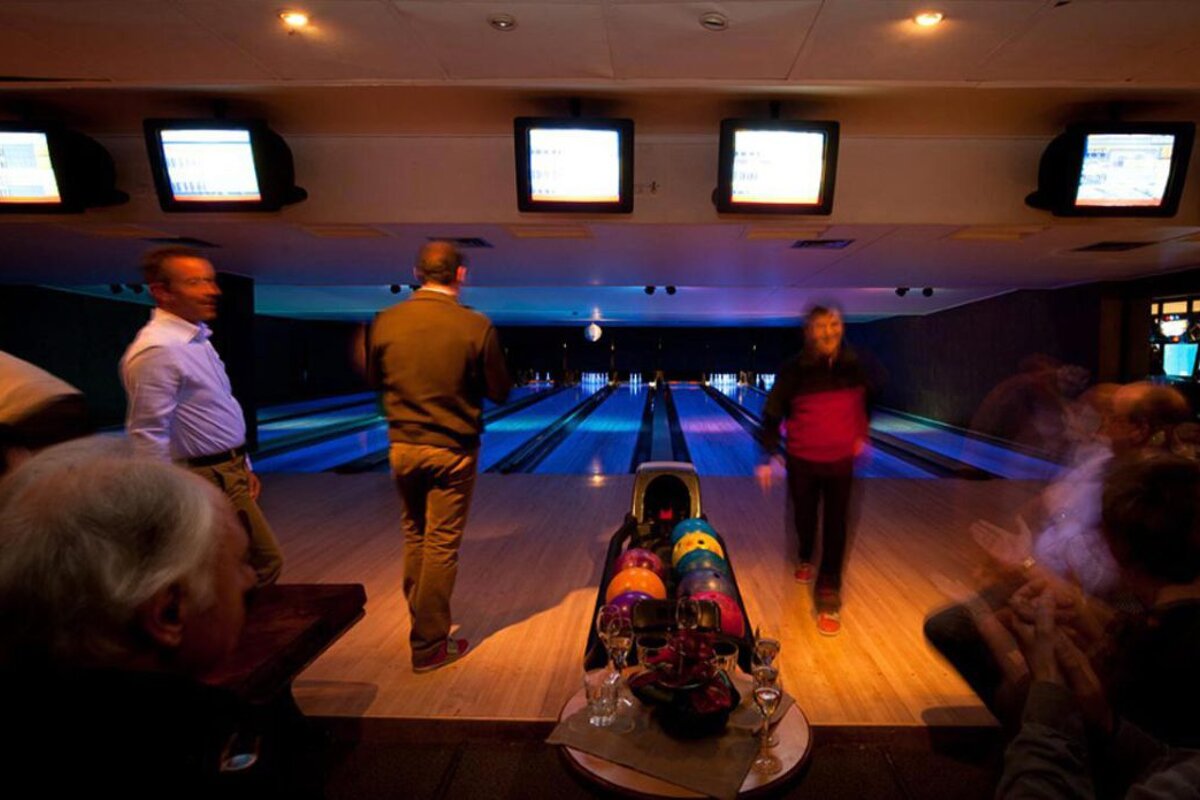 A group of people are playing bowling in a bowling alley