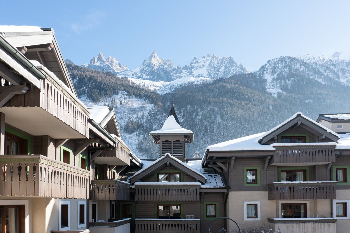 Snow covered buildings with mountains in the background