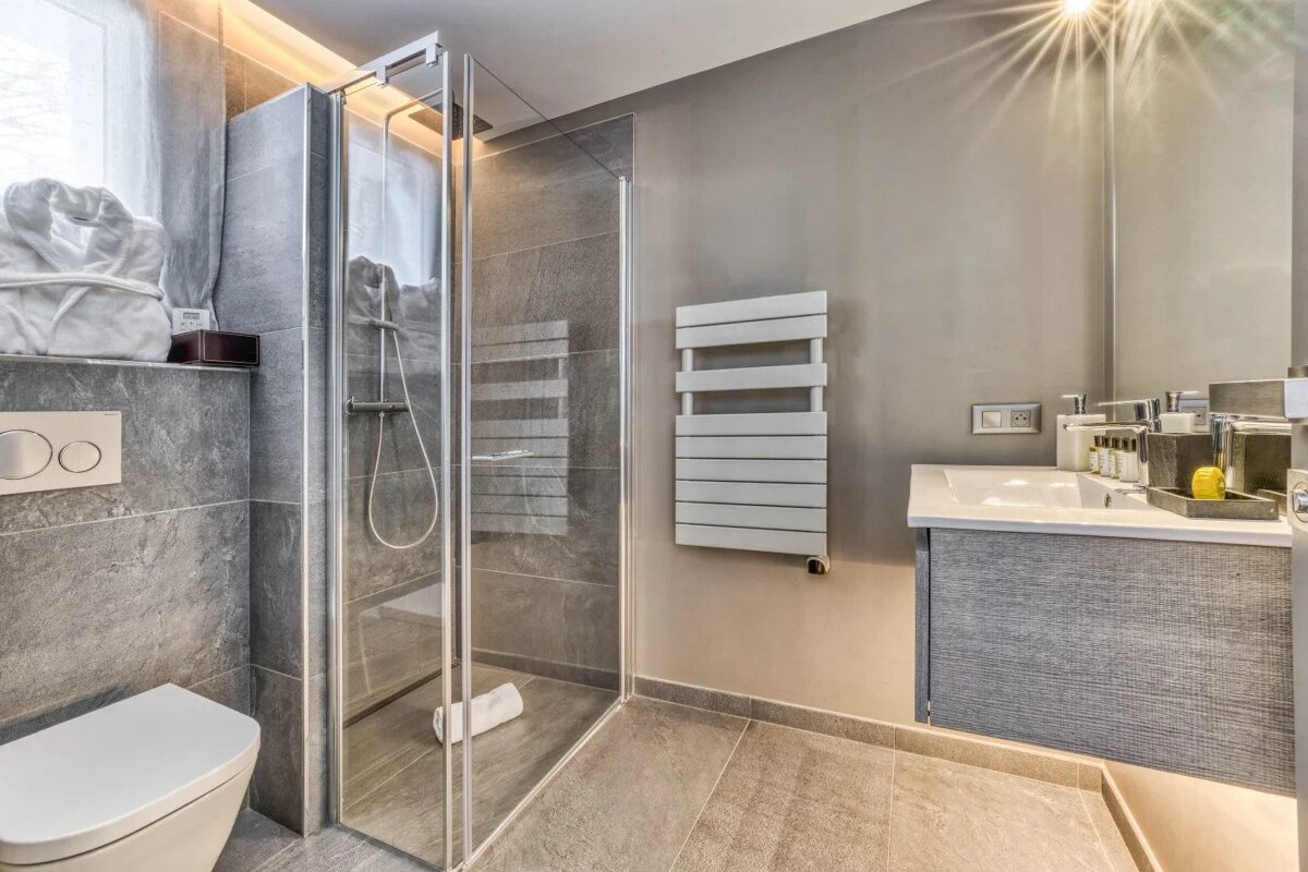 A bathroom with a toilet a sink and a walk in shower