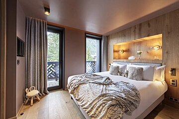 A bedroom with a large bed and a window