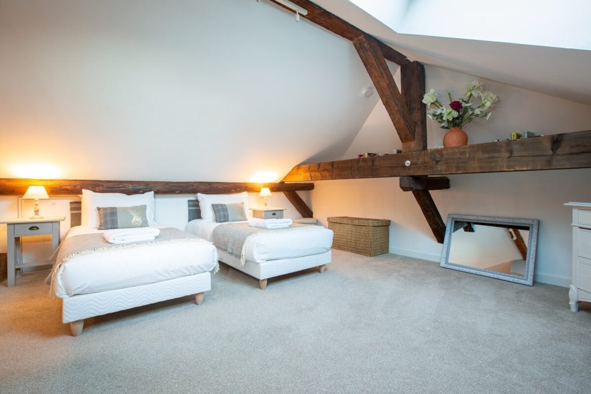 A bedroom with two beds and a mirror on the wall