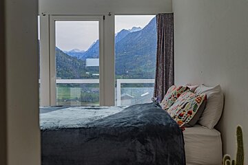 A bedroom with a bed and a view of mountains
