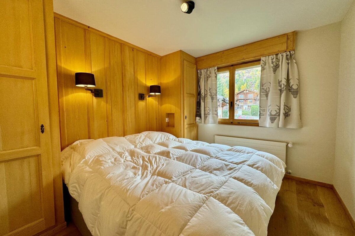 A bed with a white comforter in a bedroom