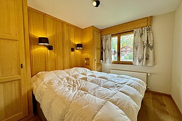 A bed with a white comforter in a bedroom