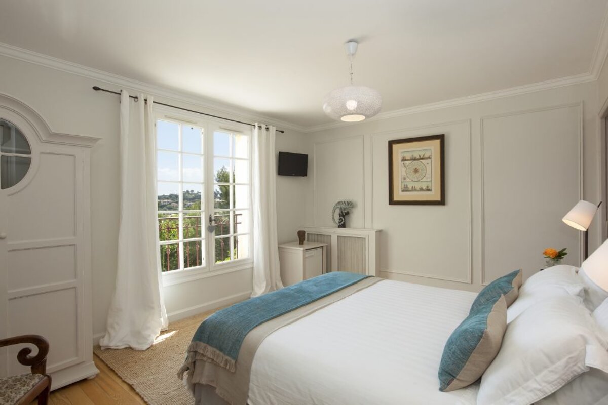 A bedroom with a bed and a picture on the wall