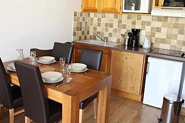 A kitchen with a table and chairs and plates on it